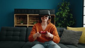Young redhead woman playing video game using virtual reality glasses at home