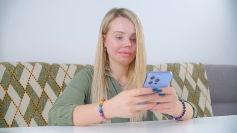 Abuse victim woman with one prosthetic eye communicating over internet with modern mobile phone. Inclusivity and violence against women concept filmed in 4k video. One-eyed female being social online