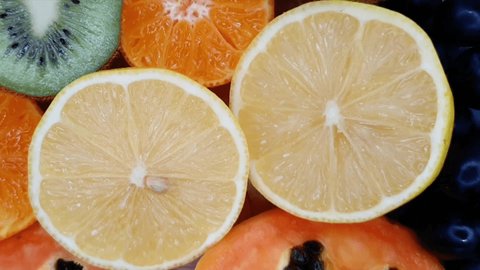 Juicy halves of a lemon.  Fruit background. Fruit slicing of lemons, tangerine, kiwi, papaya. Fresh citruses and fruits.