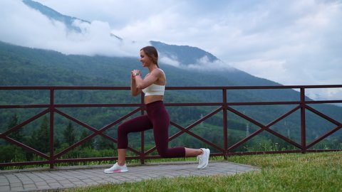 young slender woman is doing physical exercises outdoors, squatting and training legs, sporty and healthy lifestyle of modern people