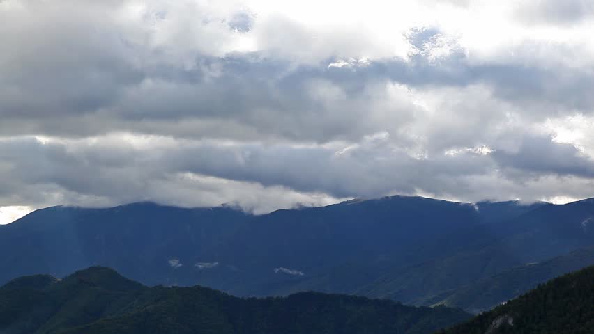 Time lapse storm clouds above forest mountain