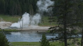 Yellowstone River flowing with hot steam rising from a geyser at Yellowstone National Park in Wyoming.
