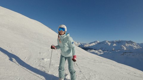 Young woman skiing on a winter holiday, camera follows skier down the slope 