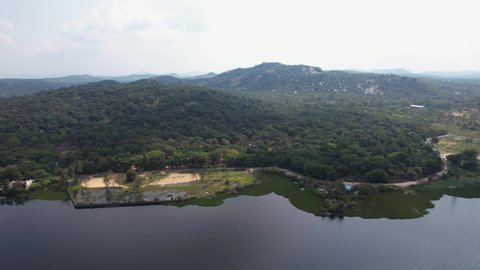Lake In The Middle Of The City Chittoor, Andhra Pradesh, India Is Surrounded By Mountains Covered With Trees And Forest. We Can See People Traveling In Roads In Their Vehicles On A Sunny Day