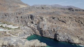 Drone footage of the Kalypso wild beach, Cretan village blue logons, coral reefs, rocky hills. Aerial mountain view. Crete island is a Mediterranean paradise. 