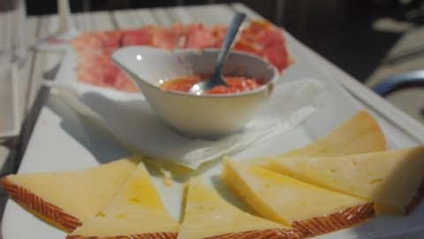 Close up of tasty Cheese plate, Teruel ham and tomato mix (pan con tomate) in a traditional Spanish tapas restaurant.