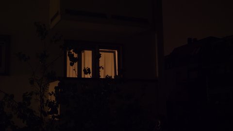 Heavy rain at night with house with light windows with multiple thunderstorms and lightings - 4K UHD footage