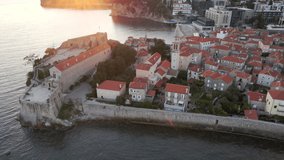 Aerial video. Slowmotion shot. The Old Town of the city of Budva popular tourist destination in Montenegro. Sunset time.