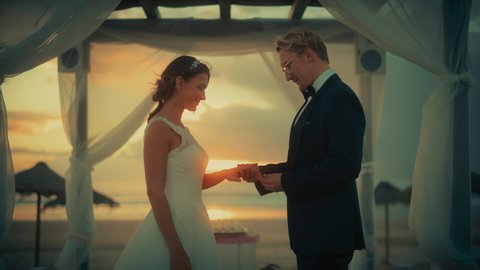 Close Up of Bride and Groom During an Outdoors Wedding Ceremony on an Ocean Beach at Sunset. Perfect Venue for Romantic Couple to Get Married, Exchange Rings, Kiss and Share Celebrations with Friends.