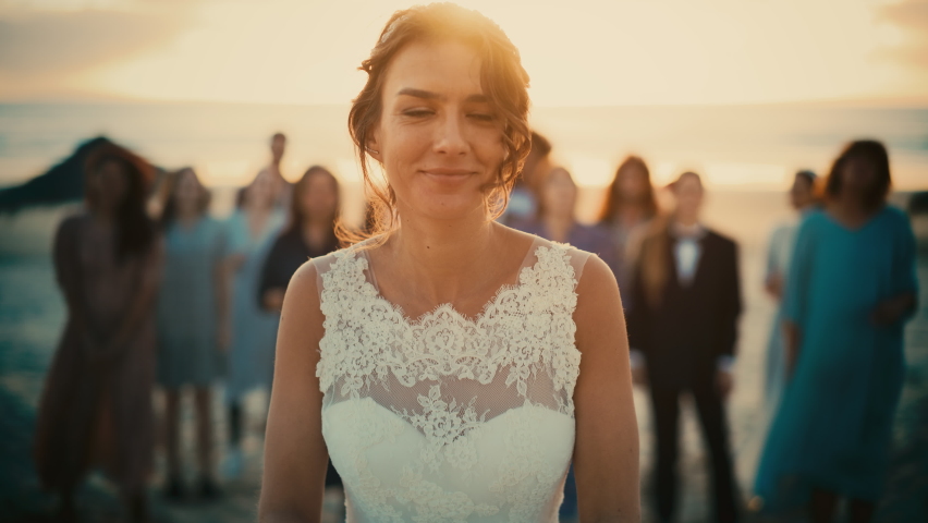 Portrait of a Beautiful Bride in Pure White Wedding Dress Tossing Bridal Bouquet and Passing Good Fortune to Her Happy Multiethnic and Diverse Friends. Outdoors Venue on a Beach Near Sea or Ocean. Royalty-Free Stock Footage #1085290457
