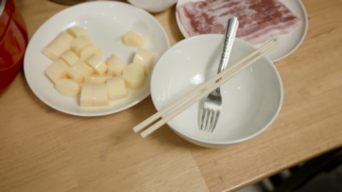4K, Thinly sliced red pork is placed on a plate to prepare sukiyaki on a table in a restaurant.