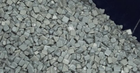 Industrial tumbling. Abrasive stones for vibration grinding metalwork production. Different shapes of machinery material for metal grinder. Heavy machine equipment wet pebble with water stream closeup