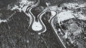 Travel journey and vacation concept High angle aerial view drone video on the curved serpentine road car driving in mountain range with white snow in winter day near Knjazevac in Serbia