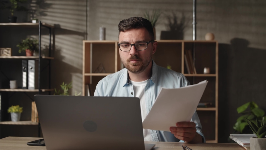 Stressed young male manager employee entrepreneur in eyeglasses crumping paper documents, feeling nervous analyzing data statistics reports | Shutterstock HD Video #1085293721