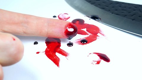Man cut his finger with a knife. Finger with blood. Red Bloody fingerprints on the white background. Horror and crime scene concept. Halloween postcard.