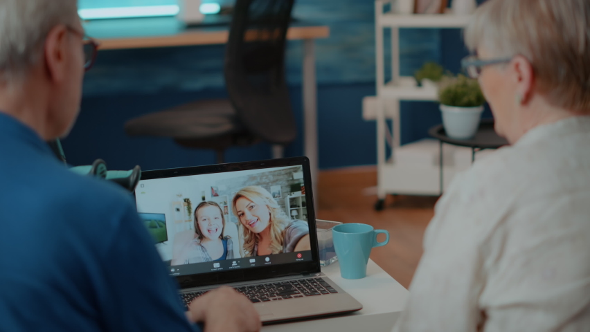 Grandparents using online conference on laptop computer to chat with family. Senior people talking to relatives on remote teleconference meeting, looking at screen. Telecommunication Royalty-Free Stock Footage #1085297609