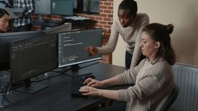 Junior developer writing source code under senior dev supervision sitting at desk with multiple screens showing programming interface. Programer writing algorithm with the help of colleague. - Powered by Shutterstock - Get 15% off with code: PIKWIZARD15