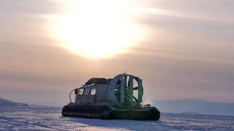 Khuzhir, Russia- March 1, 2021: Hovercraft is getting ready to drive off on snow covered ice surface of Lake Baikal at dusk.