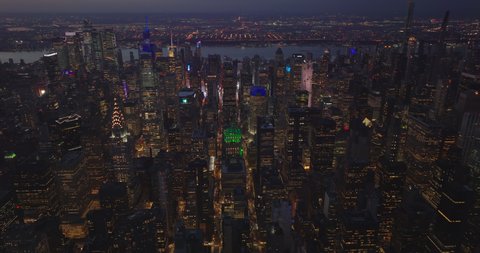 Aerial evening footage of rows of skyscrapers along streets in midtown. Cityscape after sunset. Manhattan, New York City, USA