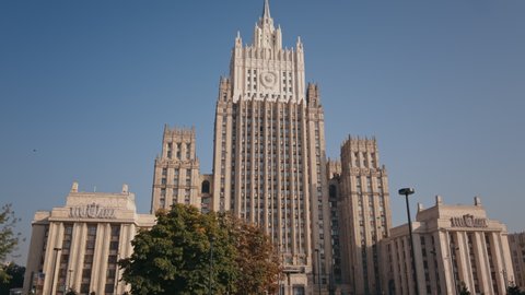 MOSCOW, RUSSIA CIRCA July 2021: Dolly pano view shot throw the trees of the building of the Ministry of Foreign Affairs of Russia in summer Moscow city center. Stalin's high-rise building