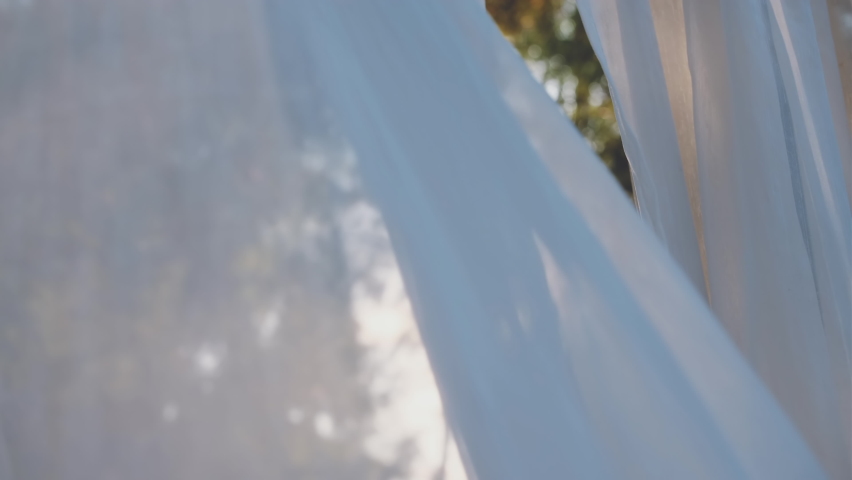 close-up of white transparent curtain fabric in wind blowing with sunshine in evening, texture background Royalty-Free Stock Footage #1085306867
