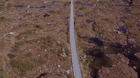 Straight road in mountains, adventure and transportation concept. Road trip, beautiful wilderness. Scenic panoramic drone shot of mountain road.