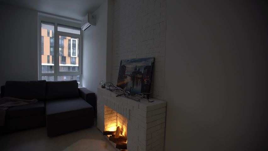 living room interior in modern minimalist design style with burning fireplace.