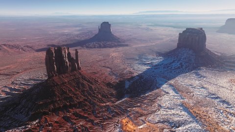 Drone point of view flying above Monument valley rock formations in Navajo land in Utah, USA. Aerial view of famous landmark from western movies, Hollywood filming location at winter, USA 4K