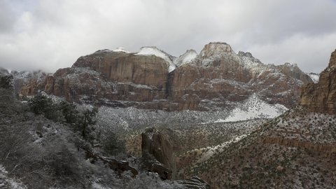 4K timelapse video of clouds drifting over the mountains of Zion National park Utah on a winter day after a fresh snowfall seen from a pull out on Zion National park Boulevard near the tunnel 