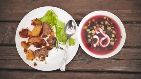 Roast potatoes with meat and red with borscht served for dinner.
