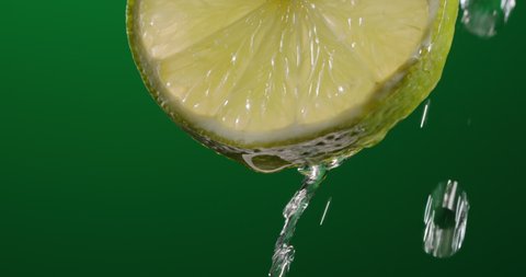 Water running down fresh pulp of lime. Citrus fruit rich in vitamin c used in healthy diets, lemonades and detox drinks - food and drink close up 4k footage