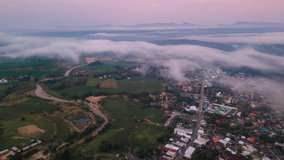 Aerial view Time-lapse of dawn sky with fog or clouds over the small town among the valley at Mae Hong Son province Unseen journey in Northern Thailand. Still and tilt-up effect in this video