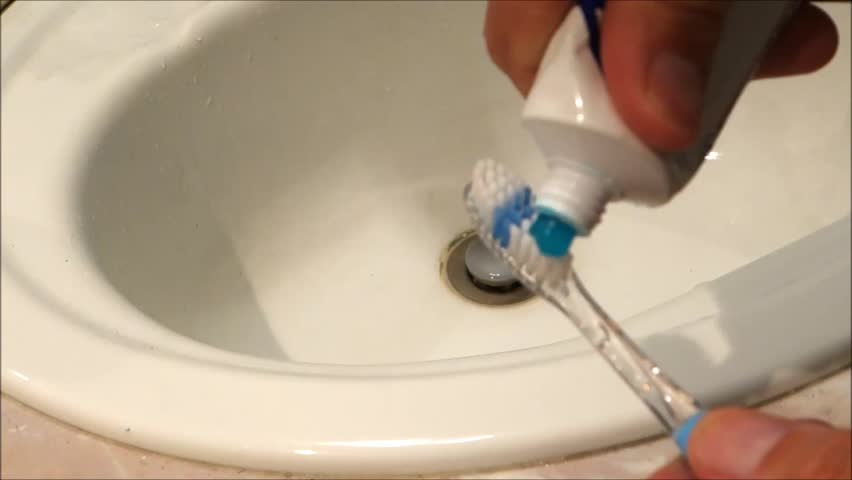 putting toothpaste on toothbrush