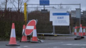 Defocused Wide Shot of Car Driving Past COVID 19 Testing Site Exit . High quality video footage