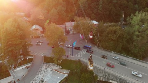 Aerial view of the retro cable car in Kutaisi city, Georgia. Yellow cable car in the city center of Kutaisi at sunset. Drone footage of the ropeway of Kutaisi. Cityscape of Kutaisi with old cableway 