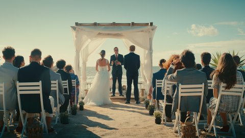 Beautiful Bride and Groom During an Outdoors Wedding Ceremony on a Beach Near the Ocean. Perfect Marriage Venue for Romantic Couple in Love and Best Friends with Multiethnic Diverse Cultures.