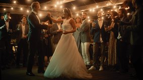 Beautiful Bride in White Dress and Groom in Stylish Black Suit Celebrate Wedding at an Evening Reception Party. Newlyweds Dancing at a Venue with Best Multiethnic Diverse Friends. - Powered by Shutterstock - Get 15% off with code: PIKWIZARD15