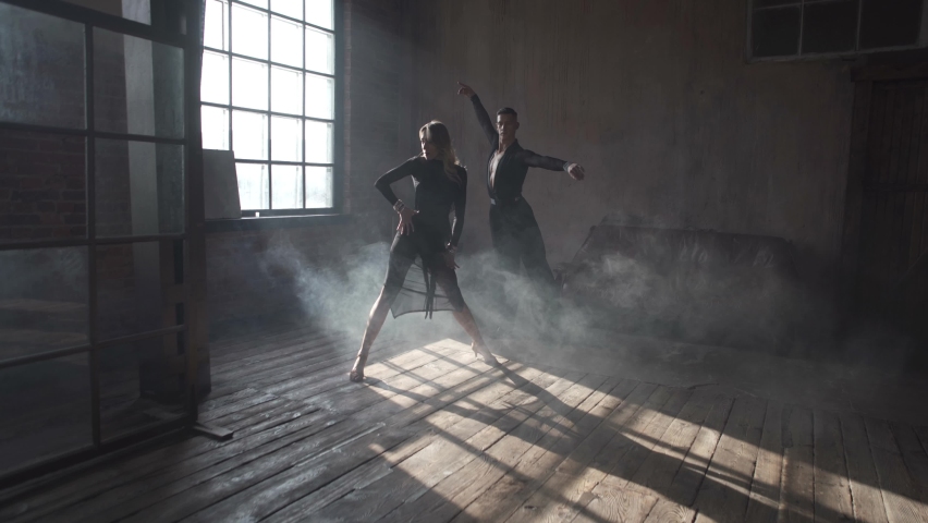 Couple of two professional modern dancers is dancing on loft studio. Beautiful art performance with heavy smoke. Sport life concept. Passion and emotional dance.