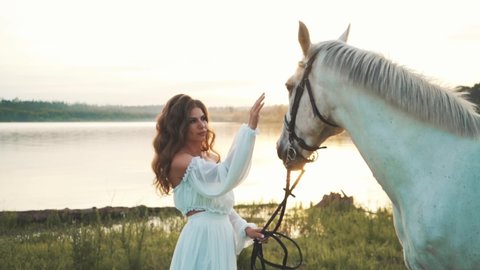 Girl in a white dress on a horse. Bride riding a horse in the field. Slow motion. High quality FullHD footage