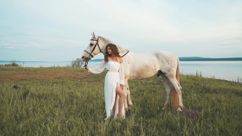Girl in a white dress on a horse. Bride riding a horse in the field. Slow motion. High quality FullHD footage
