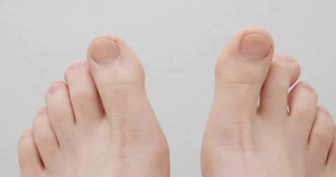 Male bare feet against white background. Close up slider shot, real time, laying still