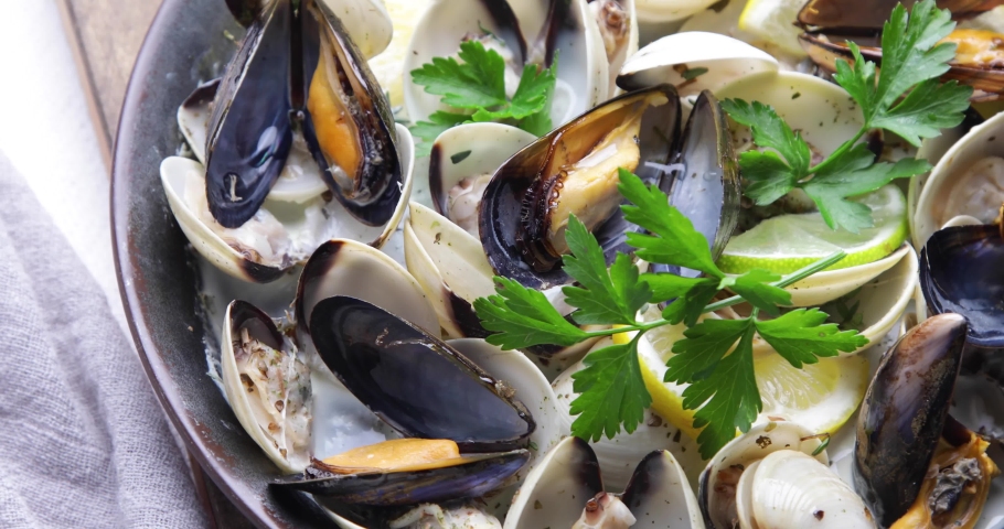 Mussels in a pan with parsley and lemon | Shutterstock HD Video #1085356340