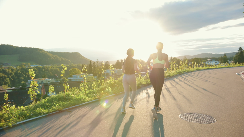 Young athlete women running down the street, training hard, getting ready for race competition or marathon. Concept of healthy running and outdoor exercise.