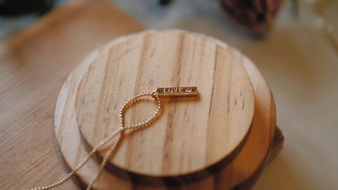 Shift focus Gold jewelry love chain necklace on wooden