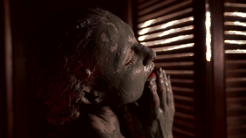 sensual portrait of adult woman covered by clay, hair and face in cosmetic or artistic mud