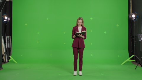 Young caucasian business woman making notes in notepad on a Green Screen, Chroma Key.