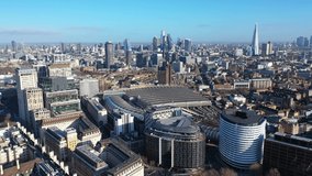 Aerial drone video of famous central train station of Waterloo and City of London iconic skyline at the background, United Kingdom