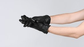 A man wearing black gloves claps his hands with the back of his hand. Side view. 4K UHD video footage 3840X2160. - Powered by Shutterstock - Get 15% off with code: PIKWIZARD15