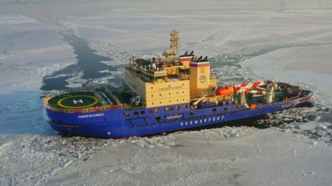 Drone view of the diesel-electric icebreaker Novorossiysk at anchor among the ice at dawn. Ensuring navigation during the laying of a frozen sea channel - JAN 08, 2022 VLADIVOSTOK, RUSSIA