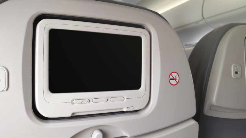 White LCD Screen in an Airplane Seat Turning On Chroma Key Green Screen. Zoom In. Close Up. 4K Resolution. Royalty-Free Stock Footage #1085378660